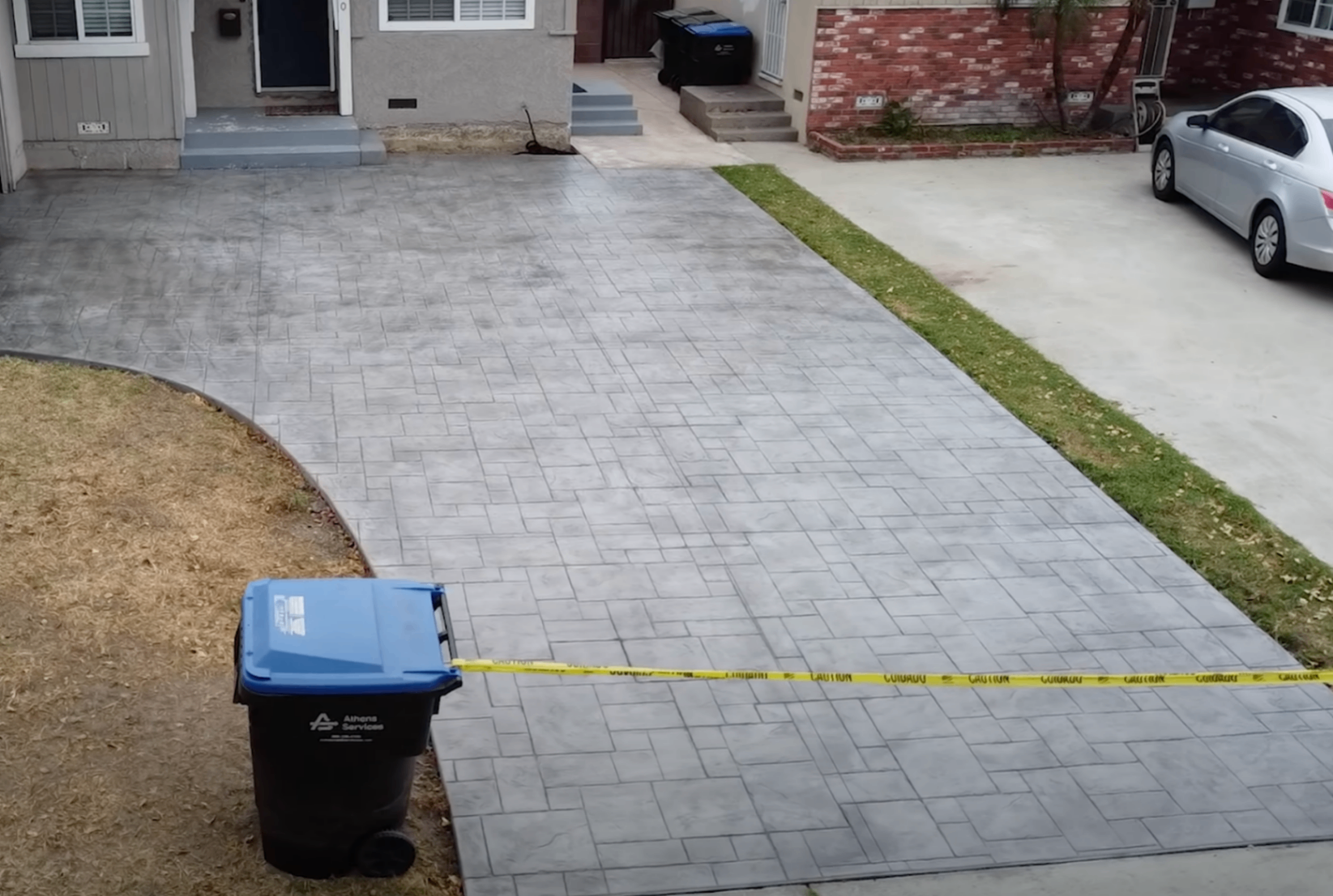 finisher pressing an ashlar slate stamp mat into fresh colored concrete on a Columbus patio